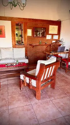 a room with two wooden beds and a table at Cabanas Las Pencas, HOSTERIA in Mina Clavero