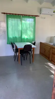 a table and chairs in a room with a green curtain at La Casita in Los Reartes