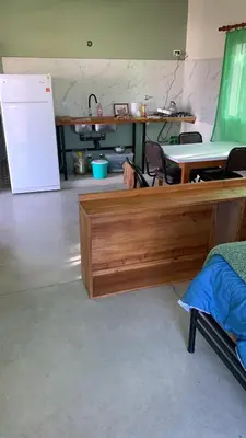 a room with a wooden bed and a refrigerator at La Casita in Los Reartes