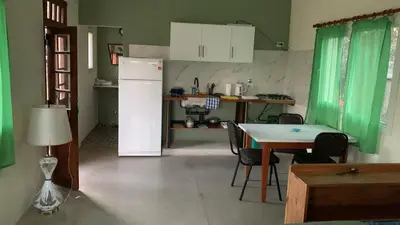 a kitchen with a white refrigerator and a table with chairs at La Casita in Los Reartes