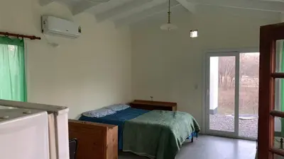 a bedroom with a bed and a sliding glass door at La Casita in Los Reartes