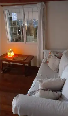 a room with two beds and a table with a candle at Departamento próximo terminal y hospitales in Cordoba