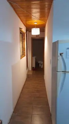 a hallway leading to a room with a refrigerator at Departamento próximo terminal y hospitales in Cordoba