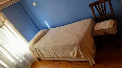 a bed in a blue room with a window at Departamento próximo terminal y hospitales in Cordoba