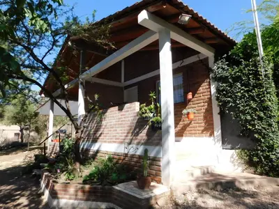 a house with a cross on the front of it at Un lugar en el mundo in Mina Clavero