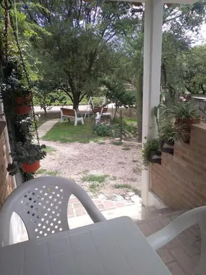 a patio with a table and chairs on a porch at Un lugar en el mundo in Mina Clavero
