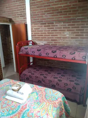 a room with a bench with a table and a brick wall at Un lugar en el mundo in Mina Clavero
