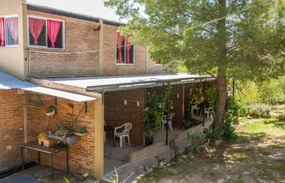 a brick house with a patio with a table and chairs at Un lugar en el mundo in Mina Clavero