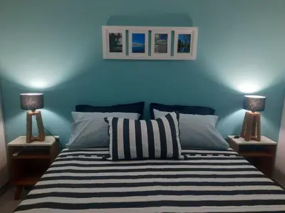a blue bedroom with a bed with two lamps at Lacus. Casas de lago. in Almafuerte