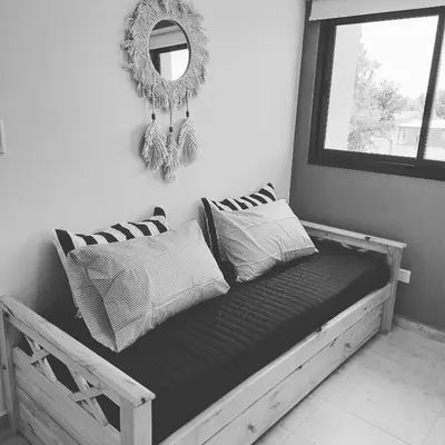 a bed with pillows and a mirror in a room at Lacus. Casas de lago. in Almafuerte