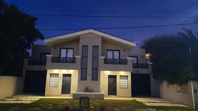 a white house with lights in front of it at Lacus. Casas de lago. in Almafuerte