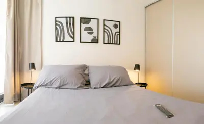 a bedroom with a bed with a remote control on it at Departamentos General Paz by Lugar in Cordoba