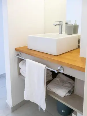 a bathroom with a sink and towels on a shelf at Departamentos General Paz by Lugar in Cordoba