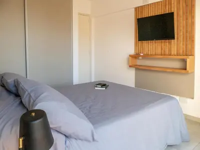 a bedroom with a bed with a tv on the wall at Departamentos General Paz by Lugar in Cordoba