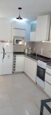 a kitchen with white cabinets and a white refrigerator at Das thomy in Cordoba