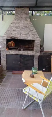a table and chairs in front of a brick oven at Das thomy in Cordoba
