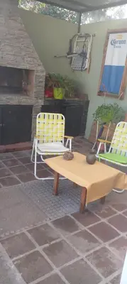 a patio with two yellow chairs and a table and chairs at Das thomy in Cordoba