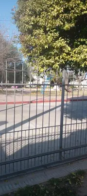 a fence on the side of a street with a tree at Das thomy in Cordoba