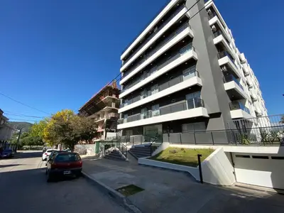 a parking lot in front of a tall building at Edificio Veneto III - Departamento de un dormitorio a pocas cuadras del centro in Villa Carlos Paz