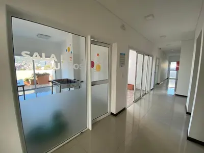 a corridor of a building with glass doors at Edificio Veneto III - Departamento de un dormitorio a pocas cuadras del centro in Villa Carlos Paz