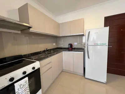 a kitchen with white cabinets and a white refrigerator at Edificio Veneto III - Departamento de un dormitorio a pocas cuadras del centro in Villa Carlos Paz