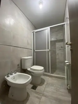 a bathroom with a toilet and a shower and a sink at Edificio Veneto IV - Departamento de un dormitorio a una cuadra de la peatonal in Villa Carlos Paz