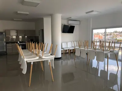 a dining room with a table and chairs and a kitchen at Edificio Veneto IV - Departamento de un dormitorio a una cuadra de la peatonal in Villa Carlos Paz