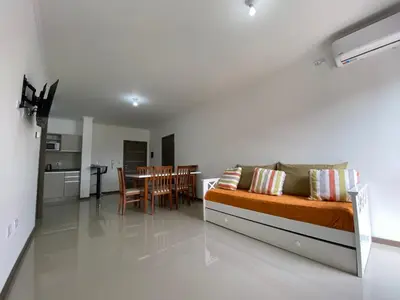 a living room with a bed and a dining room at Edificio Veneto IV - Departamento de un dormitorio a una cuadra de la peatonal in Villa Carlos Paz