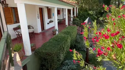 a porch of a house with pink flowers at La Casa de Pipa in Mina Clavero