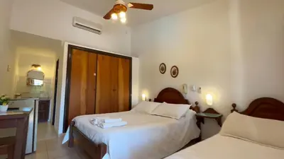 a bedroom with two beds and a kitchen at La Casa de Pipa in Mina Clavero