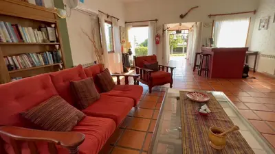 a living room with a red couch and a table at La Casa de Pipa in Mina Clavero