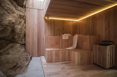a wooden room with a sauna in a stone wall at Veneto Village in Villa Parque Siquiman