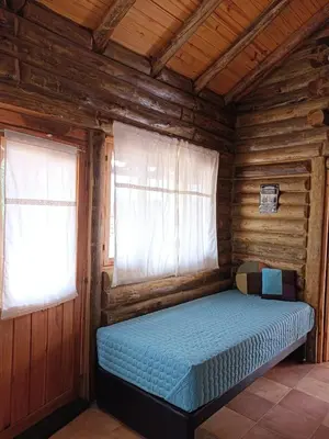 a bedroom with a bed in a wooden cabin at Sommerwind Cabañas in La Estancia