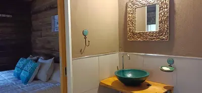 a bathroom with a green bowl on a table next to a bed at Sommerwind Cabañas in La Estancia