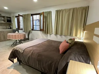 a bedroom with a bed and a table in a room at EXCLUSIVO LOFT CENTRICO in Alta Gracia