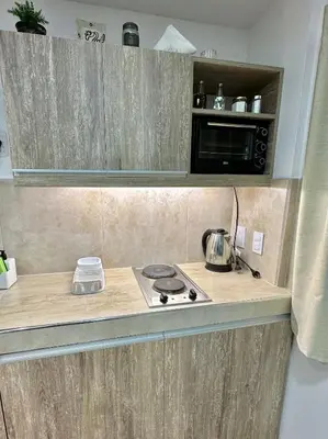 a kitchen counter with a stove and a microwave at EXCLUSIVO LOFT CENTRICO in Alta Gracia