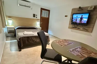 a room with a bed and a table and a television at EXCLUSIVO LOFT CENTRICO in Alta Gracia