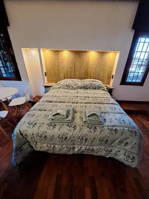 a bedroom with a bed and a table and chairs at Loft B° Urca con cochera in Cordoba