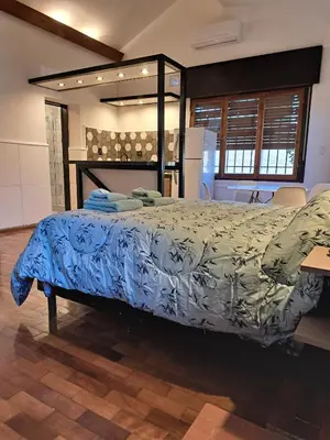 a bedroom with a bed with a blue comforter at Loft B° Urca con cochera in Cordoba