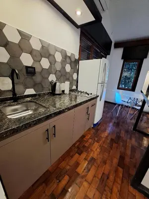 a kitchen with a sink and a refrigerator at Loft B° Urca con cochera in Cordoba