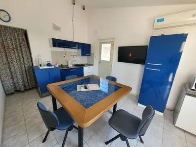a kitchen with a table and some blue cabinets at Casa en Montaña 2 habitaciones con cochera, apto mascotas in Villa Carlos Paz
