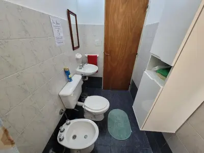 a small bathroom with a toilet and a sink at Casa en Montaña 2 habitaciones con cochera, apto mascotas in Villa Carlos Paz
