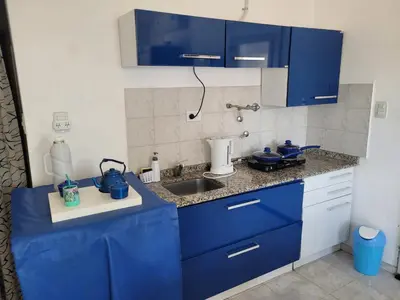 a kitchen with blue cabinets and a sink at Casa en Montaña 2 habitaciones con cochera, apto mascotas in Villa Carlos Paz