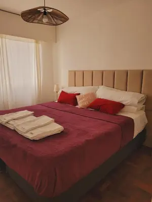 a bedroom with a bed with red and white pillows at Olmos Córdoba Apart in Cordoba