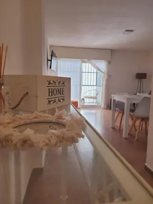 a living room with a table with a home sign on it at Olmos Córdoba Apart in Cordoba