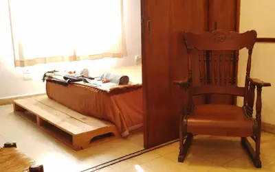 a bedroom with a bed and a chair and a window at El Estudio in Cordoba
