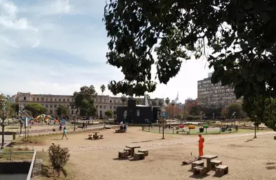 a park with benches and tables in front of a building at El Estudio in Cordoba