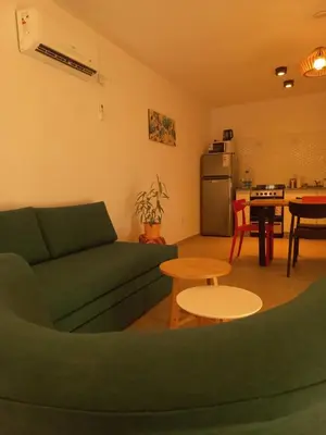 a living room with a green couch and a kitchen at TERRA CIMINTO in Villa Rumipal