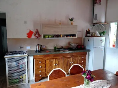 a kitchen with a refrigerator and a table with chairs at Casa Villa Alba Carpinteria in Carpintería