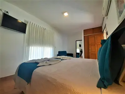 a bedroom with a large bed and a window at Hosteria Aguaribay in Mina Clavero